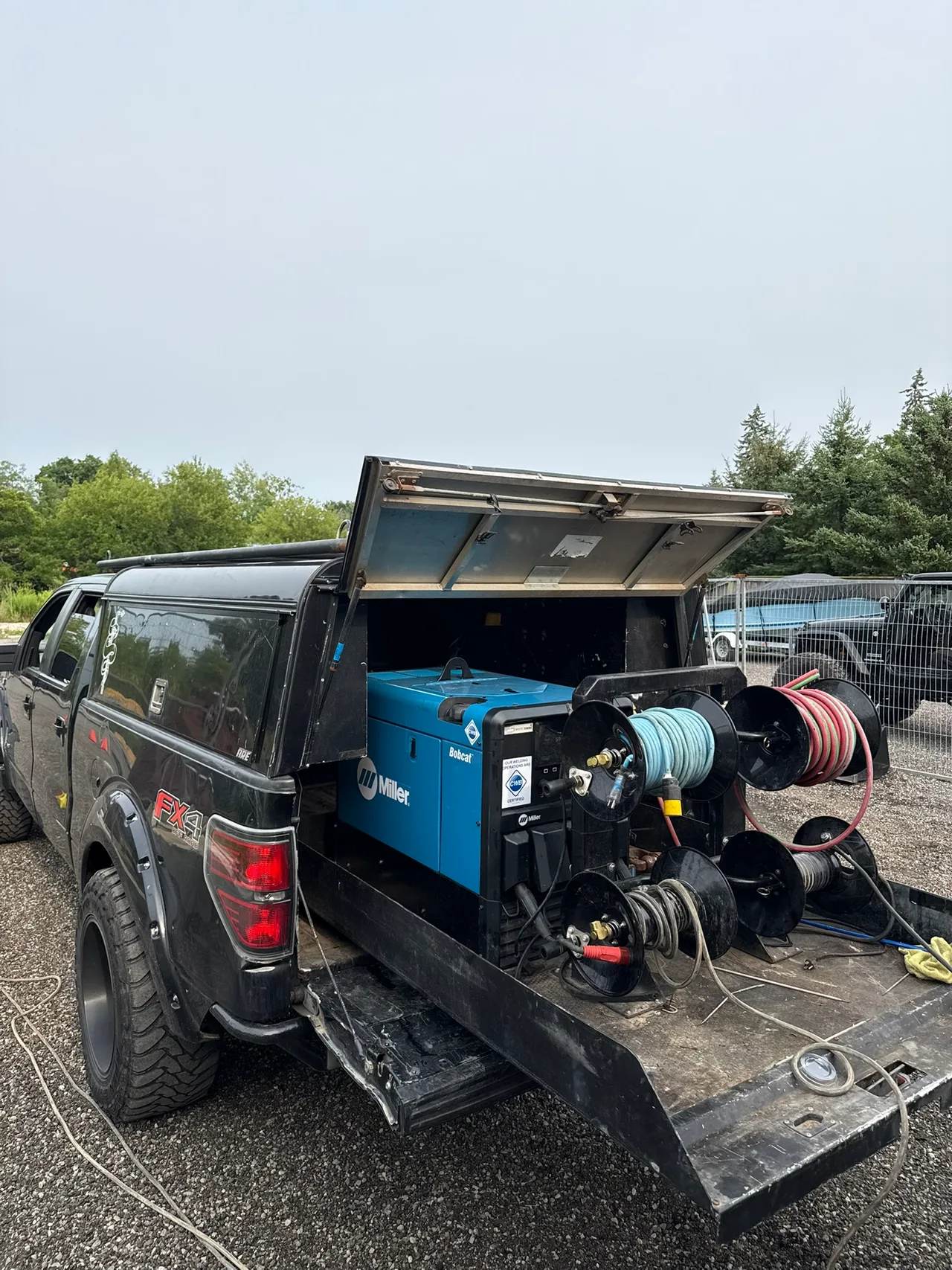 Mobile welding truck with a Miller Bobcat engine-driven welder and cable reels at the rear