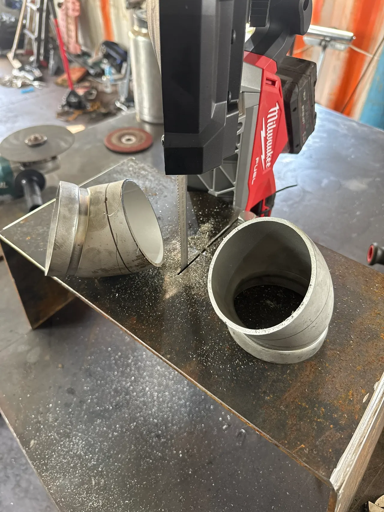 Short fabricated fittings and round metal components arranged on a workbench